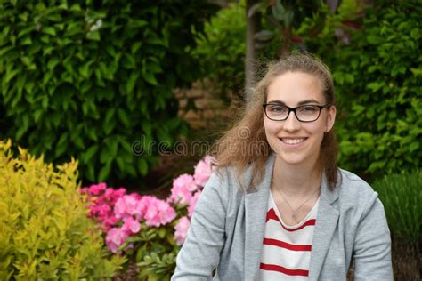 Portrait Of A Friendly Young Woman Outside In Summer Garden Stock Image