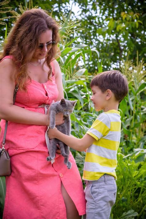 Asian Mother And Her Son Playing With Cat In The Park Stock Image