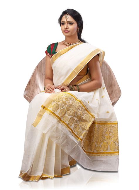 A Woman In A White And Gold Sari Sitting On The Ground With Her Hands