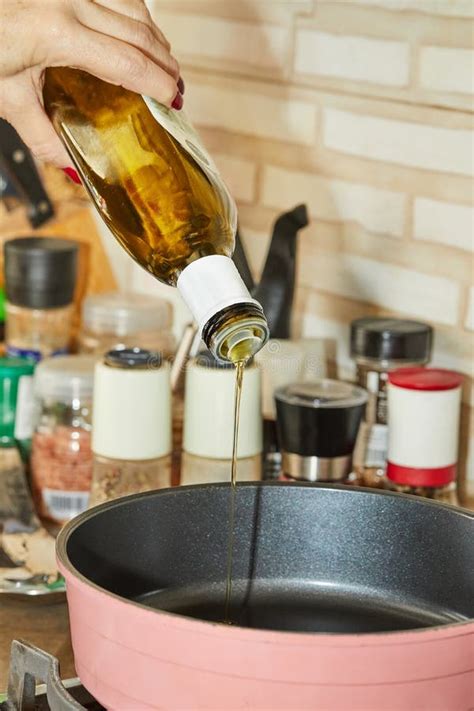 Chef Pours Olive Oil Into A Frying Pan On A Gas Stove To Prepare A Dish