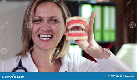 dentist woman smiles and shows plastic jaw in hands stock footage video of dentist mouth