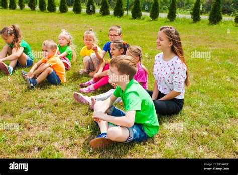Smiling Children Sitting On A Grass At Outdoor Lesson Stock Photo Alamy