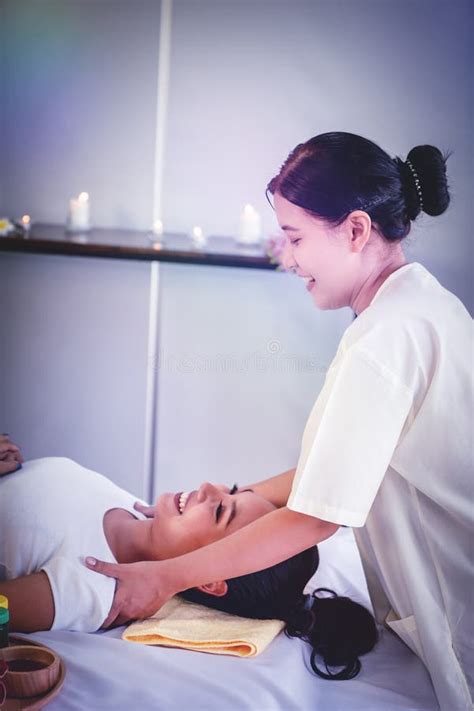 female masseur giving asian female a thai back massage in thai relaxing spa therapy stock image