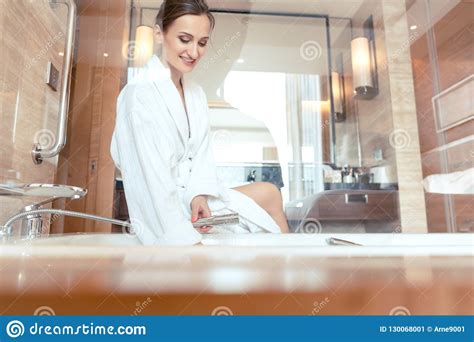 Woman In Luxurious Hotel Bathroom Letting Water In The Bathtub Stock