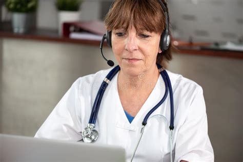 Portrait Of Female Doctor During Online Medical Consultation Stock