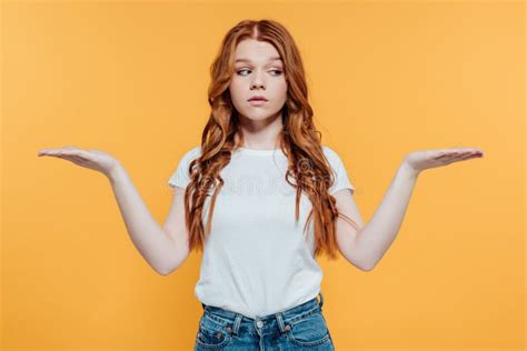 Beautiful Redhead Girl Showing Shrug Gesture Isolated On Yellow Stock Photo Image Of Emotion