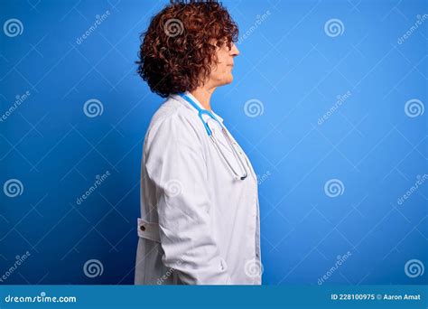 Middle Age Curly Hair Doctor Woman Wearing Coat And Stethoscope Over