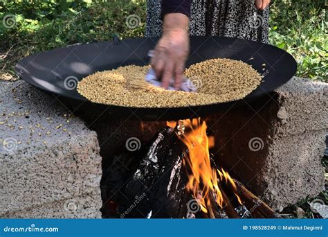 Traditional Way To Roast Wheat On Fire Of A Stone Stove Stock Image
