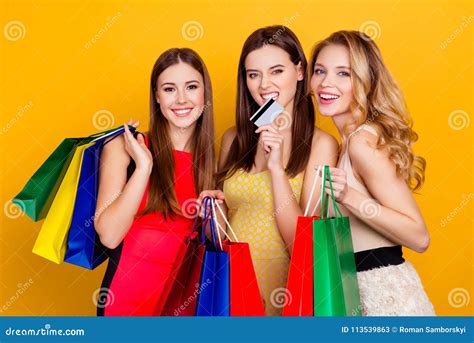 Three Pretty Charming Successful Girls Holding Colorful Shopp Stock
