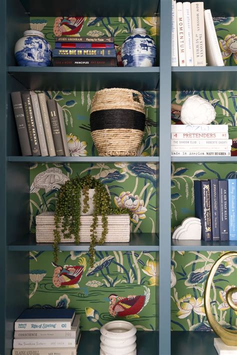 A Book Shelf With Books And Vases On It Along With Other Decorative Items