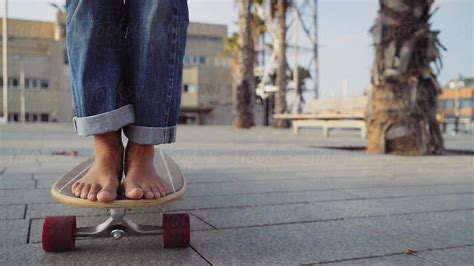 closeup of a barefoot girl skateboarding on her longboard by stocksy contributor