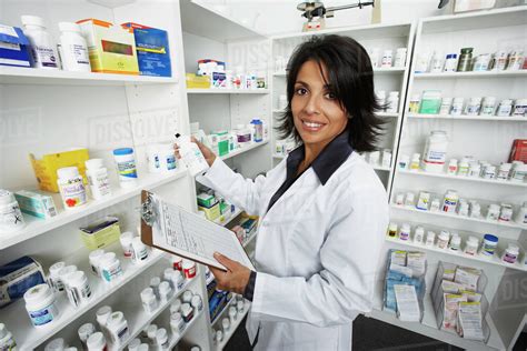 Hispanic Female Pharmacist Shelving Medication Stock Photo Dissolve