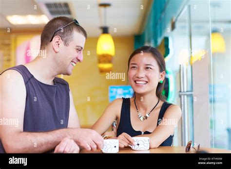 Happy Asian Girl Talking With White Man In The Cafe Stock Photo Alamy