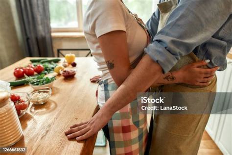 포용 부엌에 서있는 동안 포옹 하는 남자와 여자의 자른 샷 실내에서 채소를 들고 피자를 만드는 동안 포옹하는 커플 함께 요리 취미 라이프 스타일 2명에 대한 스톡 사진 및