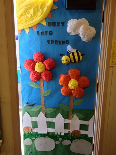 A Door Decorated With Paper Flowers And Bees In The Grass Next To A Sign That Says Buzz Into Spring