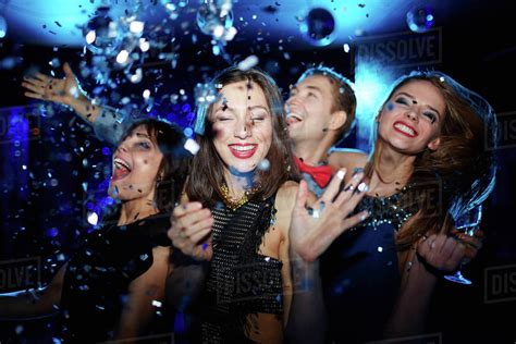 Friends Dancing At A Night Club With Confetti In The Air Stock Photo