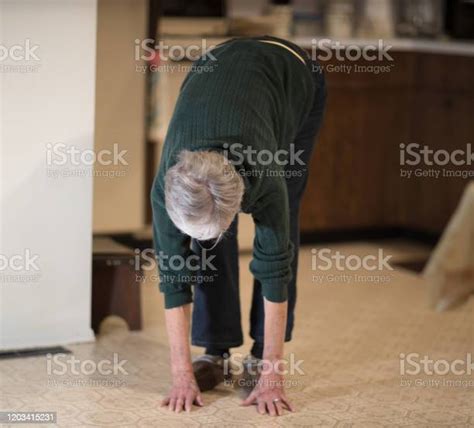 Senior Woman Bending Over To Touch Floor Stock Photo Download Image