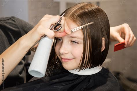 Child Getting Haircut In Beauty Salon Hairdresser Cutting Hair Little