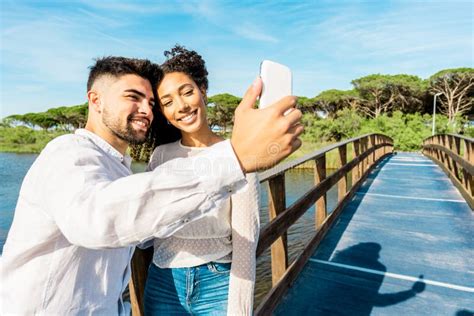 Feliz Pareja Multirracial Enamorada De Quedarse En Un Puente De Madera Tomando Un Selfie En