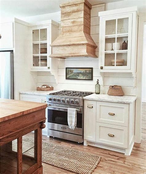 Clean White Farmhouse Kitchen With A Reclaimed Wood Range Hood And Wood