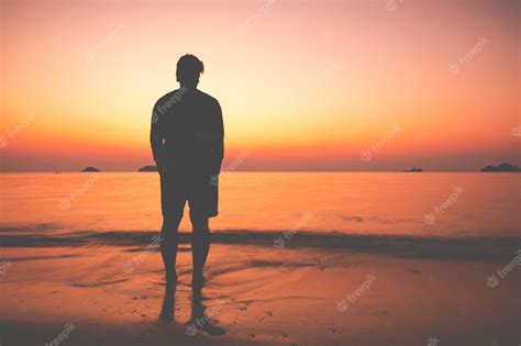 Premium Photo The Silhouette Of Man Sitting Alone At The Beach