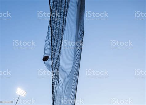 American Football Flying Into Net Behind Goal Posts Stock Photo