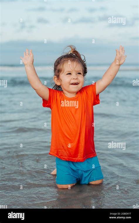 Toddler Girl Playing In The Water On Beautiful Sandy Tropical Beach In