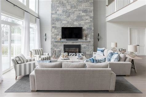 Blue And Gray Living Room With A Two Story Stone Fireplace