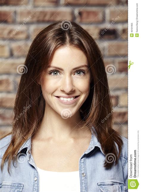 Portrait Of A Beautiful Young Woman Against Brick Wall Stock Image