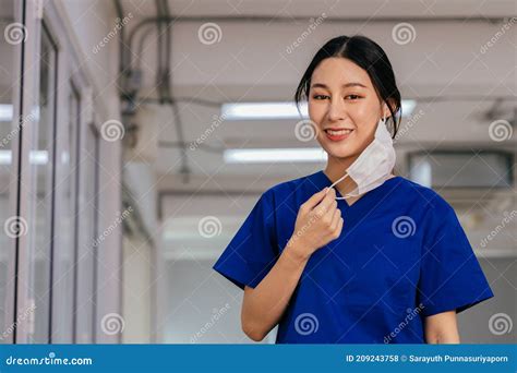 Young Beautiful Asian Medical Nurse In Scrub Uniform At Hospital Prepared To Wear A Face Mask