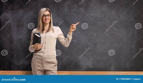 Female Teacher With Books Pointing To A Blackboard Stock Image Image Of Lecture Chalk 170844889