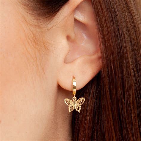 Gold Tone Huggie Earrings Feature Dangling Butterfly Charms With