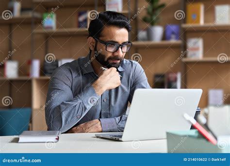 Serious Indian Business Man Working Or Studying On Laptop Computer