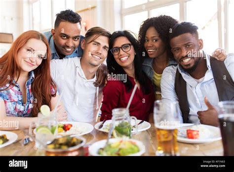 Happy Friends Eating At Restaurant Stock Photo Alamy