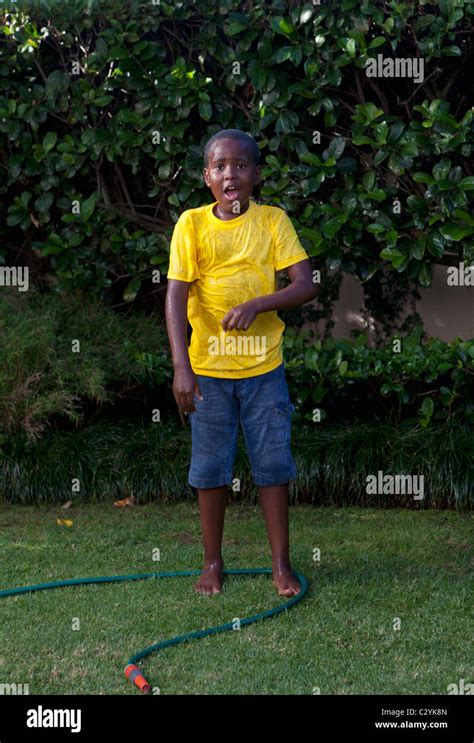 Young Boy Standing In Garden In Wet Clothes Johannesburg South Africa