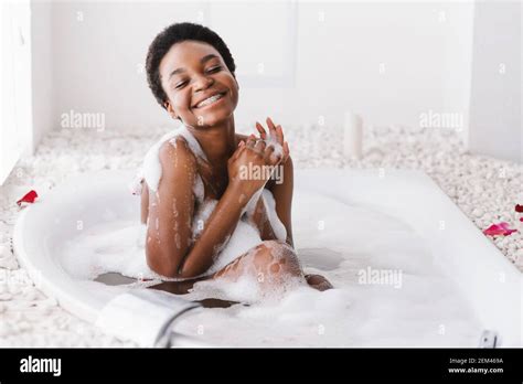 Woman With Closed Eyes Of Pleasure Taking Bath With Foam And Petals At