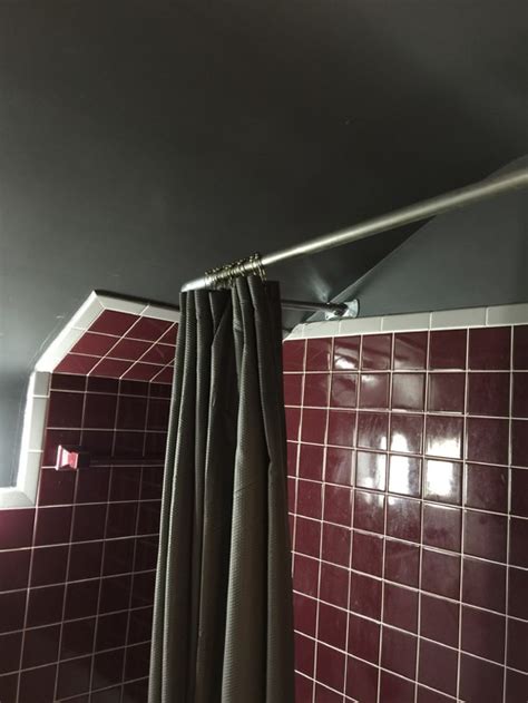 Drapery track such as ks or the standard 9000 is very low profile and allows you to mount your drape flush to the ceiling. Shower rod on sloped ceiling