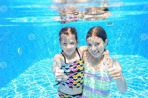 Happy Children Swim In Pool Underwater Girls Swimming Stock Image