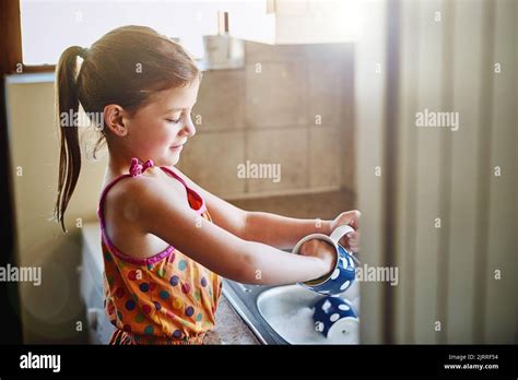 Keeping Things Clean And Tidy A Little Girl Washing Dishes At Home