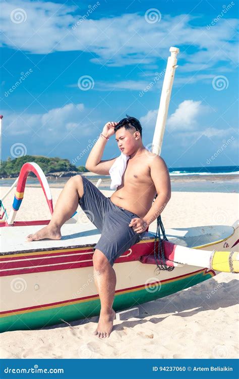 Young Asian Indonesian Man Relaxing On The Beach Of Tropical Bali