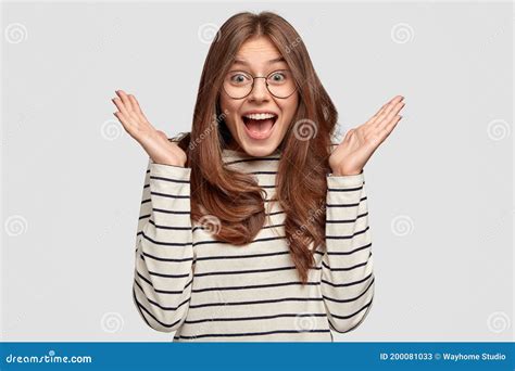 Excited Woman With Amazed Facial Expressions Keep Hands Near Face Dressed In Casual Striped