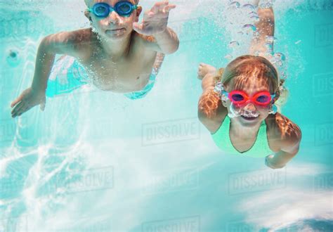 Caucasian Children Swimming Underwater In Pool Stock Photo Dissolve