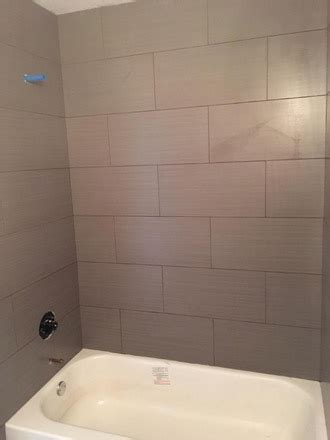 Bath tub surrounds that look like tile menards home. Wood Look Tiles and River Rock Installation in Atlantic Beach