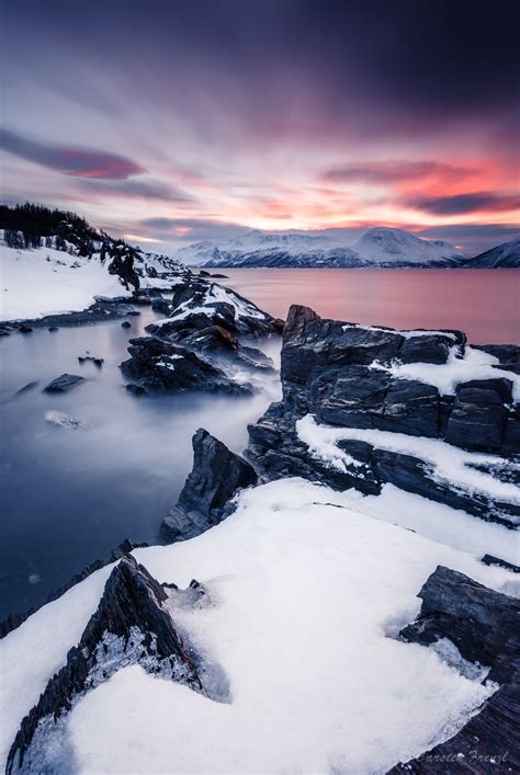 Time Lapse Photography Of Snowy Hills And Body Of Water During Golden