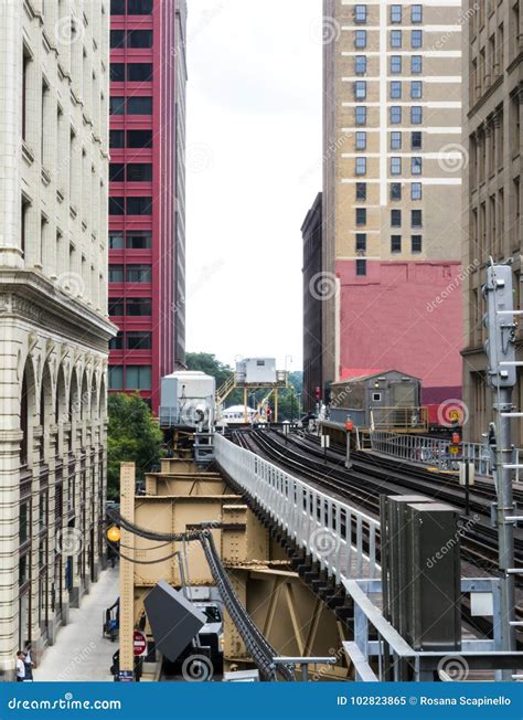 Elevated Train Tracks Above The Streets And Between Buildings At The