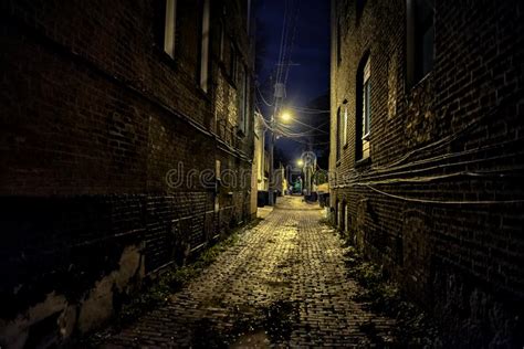 Dark And Eerie Urban City Cobblestone Brick Alley At Night Stock Image