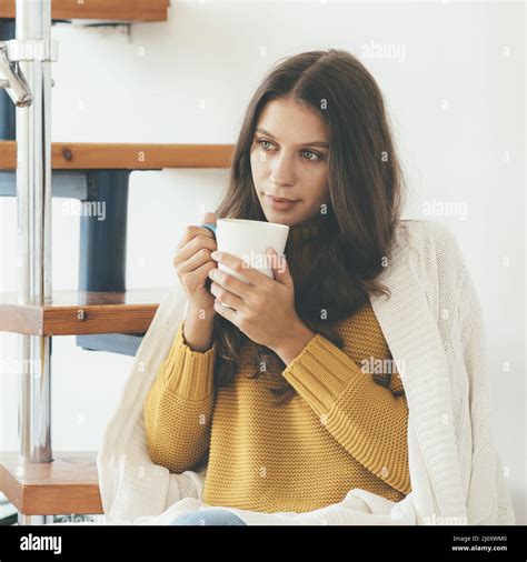 Bautiful Young Woman Sitting Onstairs In Warm Clothes And Drinking