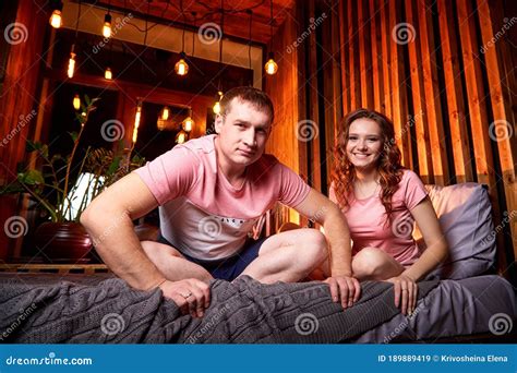 Couple In Love On The Bed Near Window In The Dark Room With Warm Yellow Night Light Stock Image