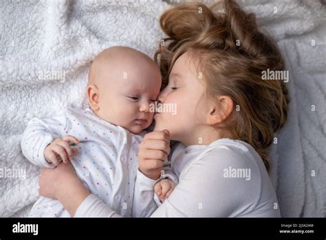 Niños Felices Niño Pequeño Y Hermana Mayor Abrazando En Casa En Una Manta Blanca Sonriendo