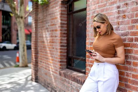 Premium Photo A Woman Stands In Front Of A Brick Wall And Looks At